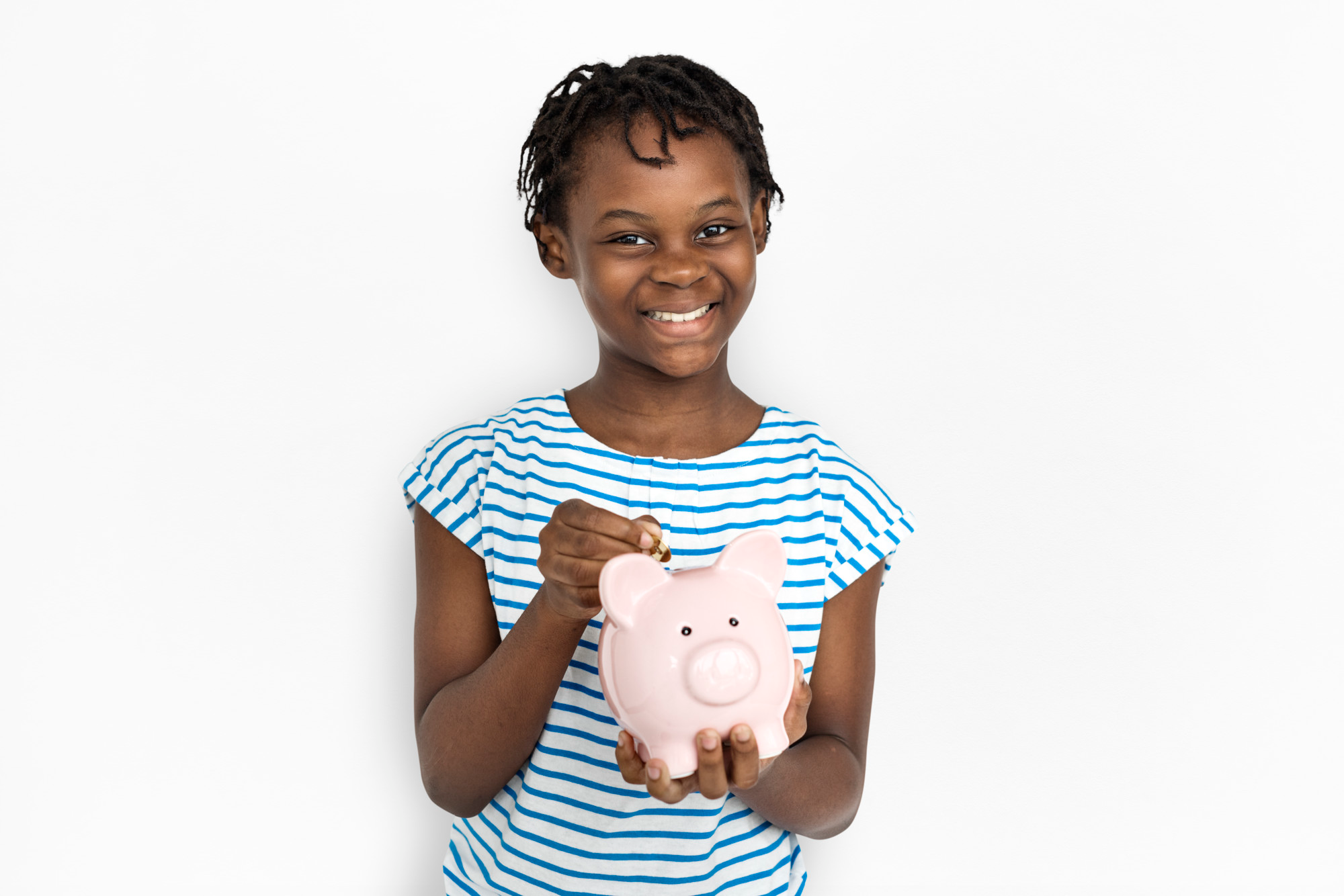 African child holding a pink piggy bank inserting a coin